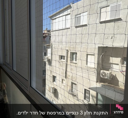 חלון אלומיניום עם רשת מול בניין מגורים